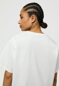 Witte katoenen t-shirt met een relaxte pasvorm, ronde halslijn en korte mouwen, met een zachte textuur en een minimalistisch ontwerp.