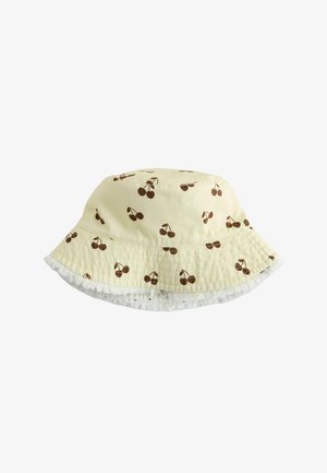 Sombrero tipo bucket de color amarillo claro con patrones de cerezas marrones y un borde blanco deshilachado a lo largo del ala.