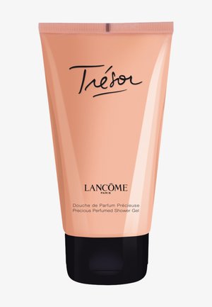 Tube couleur pêche avec une finition mate, base noire et design élégant. Porte les inscriptions �« Trésor » et « Lancôme Paris » imprimées en noir.