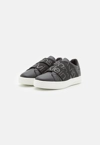 Zwarte leren sneakers met een gestructureerde afwerking en elastische banden met de merknaam, voorzien van een witte rubberen zool.