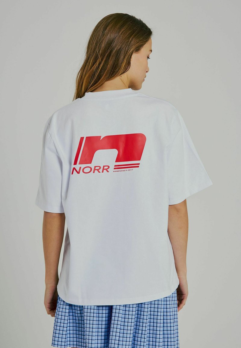 Weißes Baumwoll-T-Shirt mit kurzen Ärmeln, das auf der Rückseite ein großes rotes Logo "NORR" zeigt. Gerader Schnitt, lockere Passform, glatte Textur.