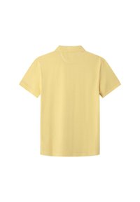 Polo à manches courtes jaune pâle vu de dos avec un col classique sur fond blanc.