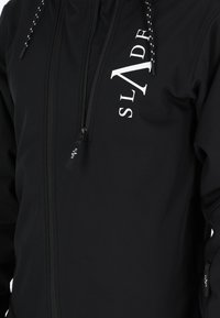 Giacca softshell nera con zip frontale, logo bianco "SLADE", cappuccio regolabile con cordini e tasche laterali.