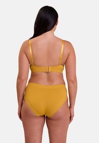 Ensemble de lingerie jaune moutarde avec une texture douce et côtelée. Le soutien-gorge est doté de bretelles en satin réglables et d'une fermeture à crochet et œillet au dos.