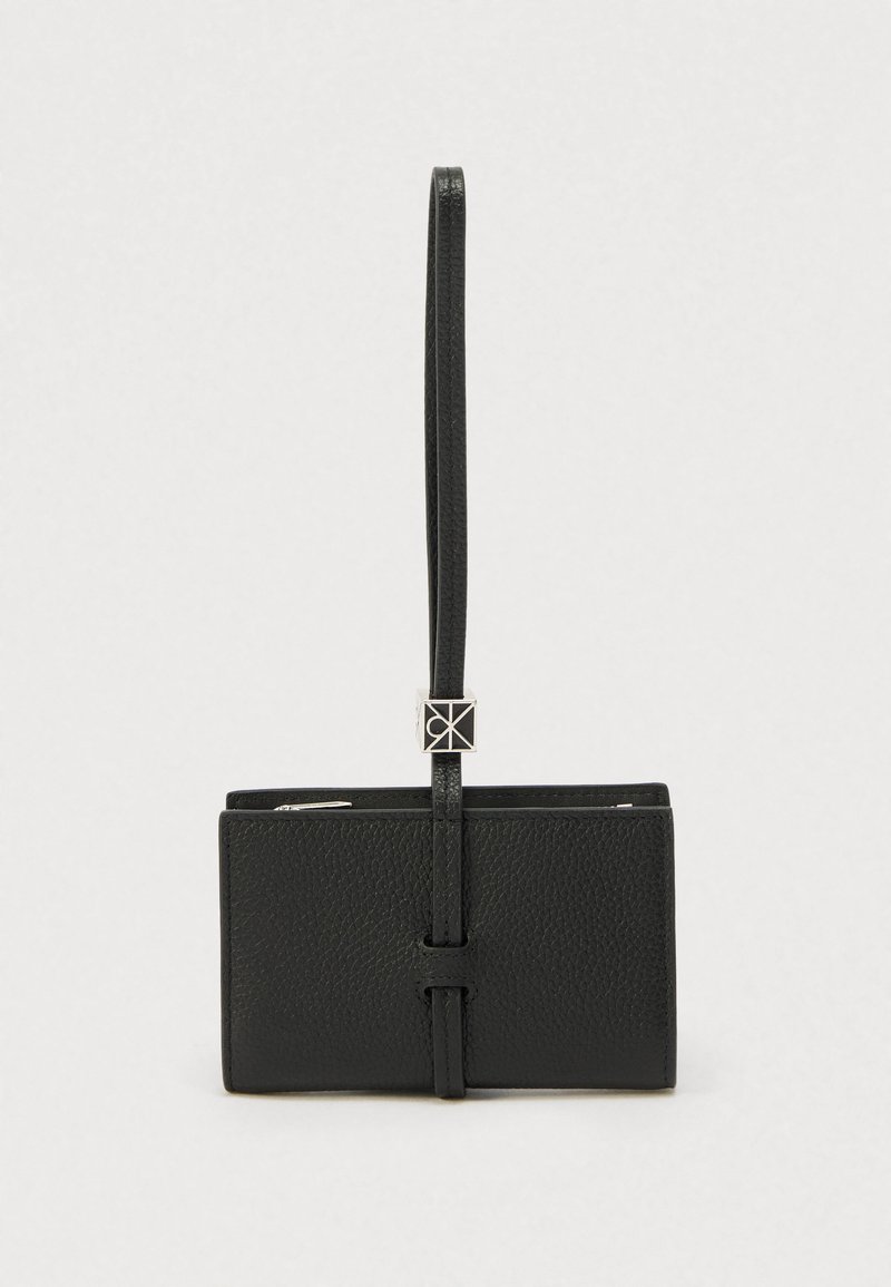 Μαύρο δερμάτινο πορτοφόλι με υφή, ιμάντα ασφαλείας και ασημένιες μεταλλικές λεπτομέρειες. Συμπαγής ορθογώνιο σχήμα με λεπτό προφίλ.