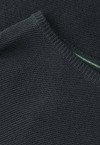 Dunkelgrauer Strickstoff mit glatter Textur und einem gerippten Kragen, der mit einem dezenten grünen Akzent, der in die Naht eingearbeitet ist, versehen ist.