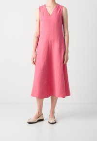 Rosa, ärmelloses Leinenkleid mit V-Ausschnitt und A-Linien-Silhouette, das bis zur Mitte des Waden reicht. Glatte Textur, minimalistisches Design, keine sichtbaren Muster.