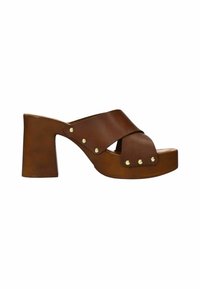 Sandales en cuir marron à plateforme avec un design à brides croisées, un talon épais et des clous décoratifs dorés sur le côté.
