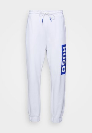 White sweatpants with elastic waistband and drawstring. Features a blue "HUGO" logo on the left leg. Cuffed hems provide a tapered fit.