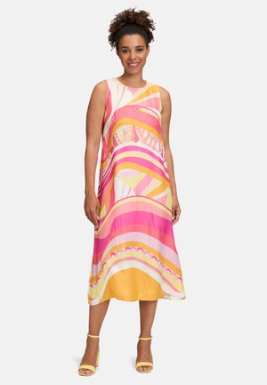 Satin sleeveless dress featuring bold pink, yellow, and orange wave patterns. Knee-length with a loose fit, complemented by yellow heels.