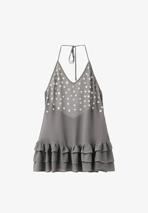 Top gris sans manches à col licou, avec sequins sur la poitrine et ourlet à volants superposés.