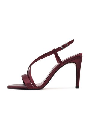 Sandalia de tacón alto color burdeos con puntera abierta, finas correas entrecruzadas, correa en el tobillo con hebilla plateada y tacón de aguja delgado.