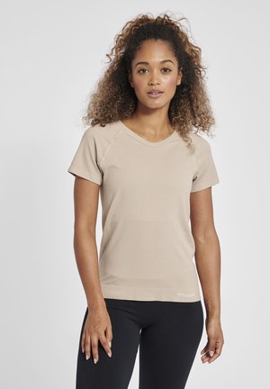 Beige idrottströja med korta ärmar, ribbad textur och rund halsringning, med en liten logotyp på nedersta vänstra sidan.