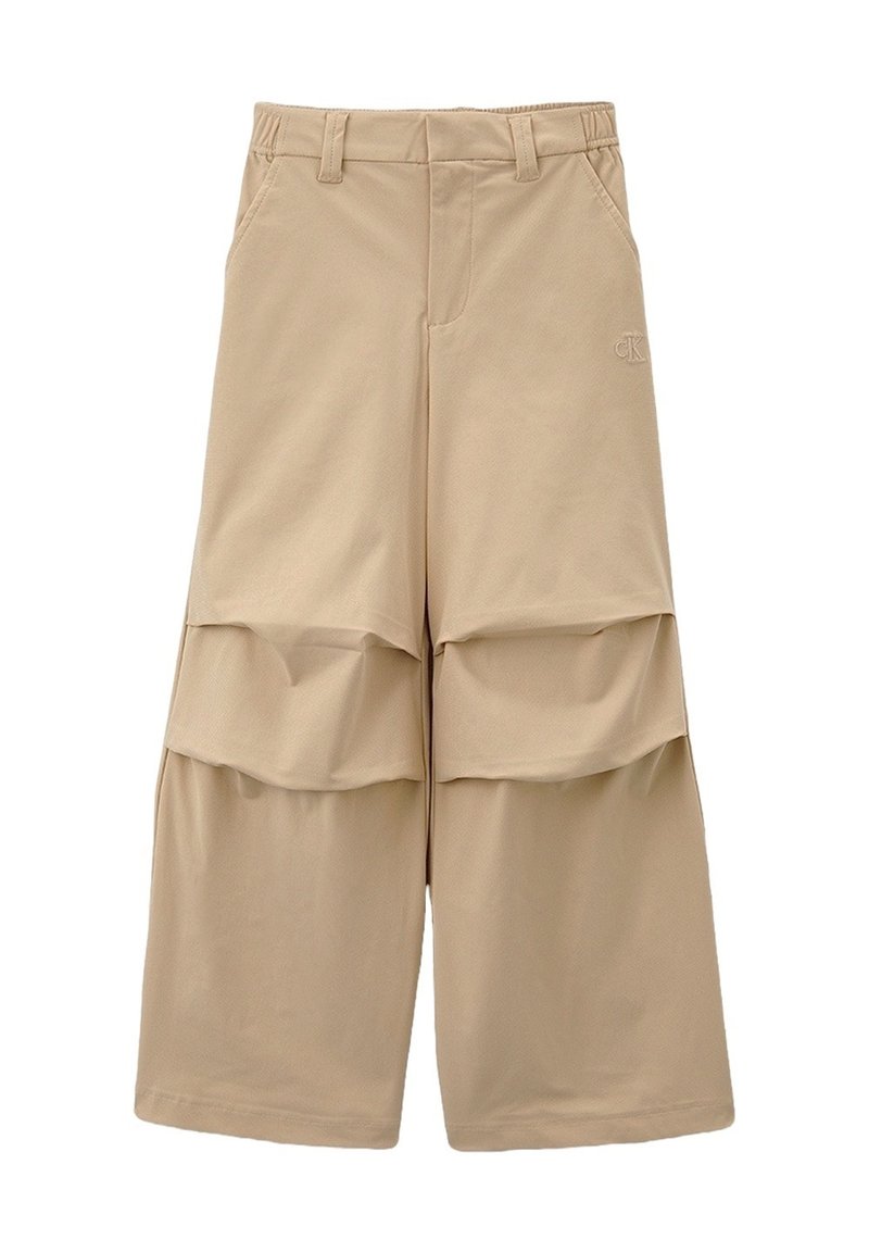 Pantaloni beige a gamba larga con dettagli in tessuto sovrapposto sulle ginocchia, passanti per la cintura, tasche frontali e logo ricamato discreto sulla coscia superiore.