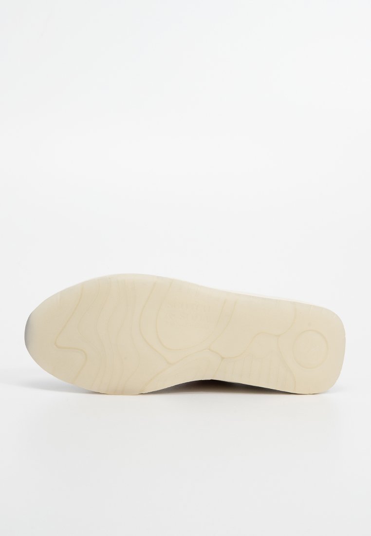 Zool van een sneaker met een gestructureerd oppervlak, in een lichte beige kleur, afgeronde vorm en een duidelijk profielpatroon voor grip.