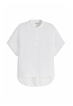 Camisa blanca de manga corta con cuello mao, tapeta de botones frontal y bajo irregular, extendida sobre un fondo blanco.