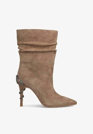 Bottines en suede tan avec un design boudiné, un bout pointu et un haut talon stiletto. Présente un matériel à motif serpent sur le talon.