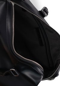 Sac en cuir noir avec une fermeture éclair en argent, offrant un intérieur spacieux et une petite poche zippée contre une doublure noire texturée.