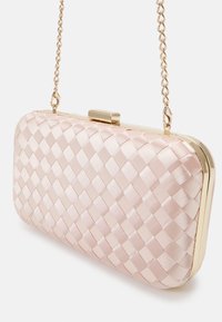 Petite pochette rectangulaire avec texture tissée en satin rose, cadre doré, fermeture à boucle et chaîne dorée suspendue sur un fond blanc.