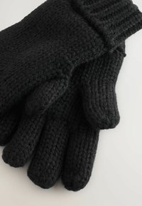 Schwarze gestrickte Wollhandschuhe mit strukturiertem Muster, flach liegend und übereinander auf einer hellen Oberfläche.