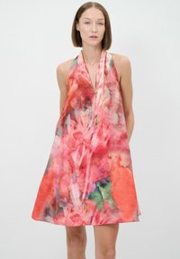 Une robe sans manches en aquarelle rose et orange avec un décolleté en V profond, ornée de motifs floraux abstraits et d'une silhouette ample et fluide.