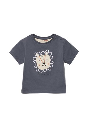 Donkergrijze t-shirt met korte mouwen, met een leeuwengezicht ontwerp in wit en beige, met daaronder de slogan "Kun je 'Grom' zeggen?" Twee drukknoopjes op de schouder.