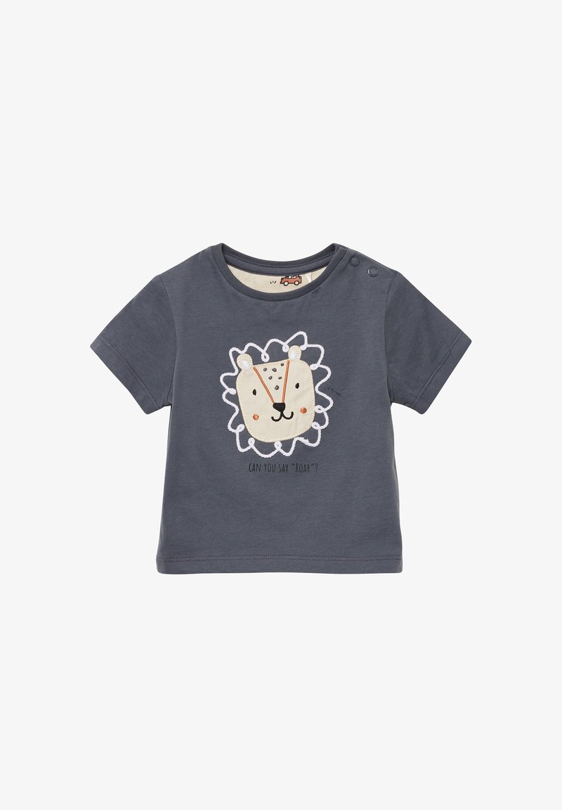 T-shirt à manches courtes gris foncé avec un design de visage de lion en blanc et beige, arborant le slogan "Peux-tu dire 'Rugir'?" en dessous. Deux boutons pression à l'épaule.