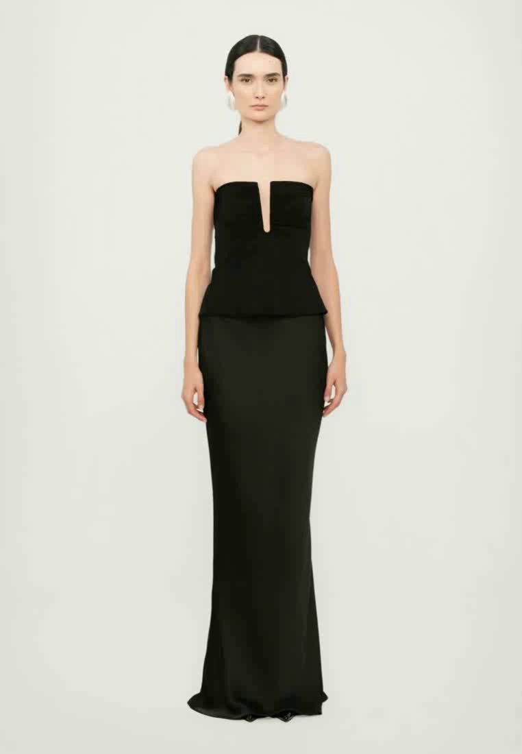 Robe noire sans bretelles avec une taille peplum, présentant un décolleté en V profond. Le tissu est lisse et a une silhouette ajustée et élégante.