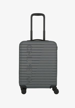 Grijze harde koffer met geprofileerd merklogo, geribbeld ontwerp, intrekbare handgreep en vier wielen voor mobiliteit.