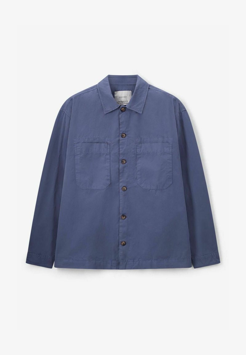 Veste en coton bleu avec col pointu, deux poches avant et boutons marron. Elle possède des manches longues et un design décontracté.