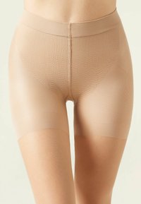 Beige Kompressionsshorts aus einem strukturierten, dehnbaren Material mit einem glatten Bund und einer Länge bis zur Mitte des Oberschenkels.