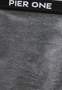 Sort sweatshirtkrave med hvid "PIER ONE" tekst over gråt stof.