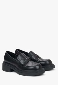 Zwarte leren loafers met een chunky hak, voorzien van een band over de voorkant en een gestructureerd ontwerp langs de randen. Glad afgewerkt.