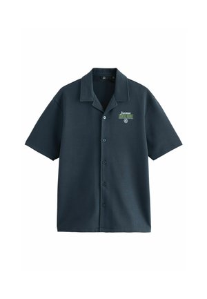 Košela s krátkym rukávom v tmavomodrej farbe z hladkej látky, s špicatým golierom, gombíkovým zapínaním a malým zeleným potlačeným logom na ľavej strane hrudníka.