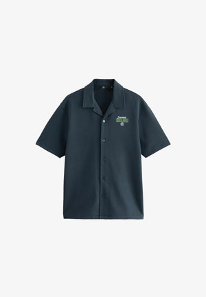 Košile s krátkým rukávem v tmavě modré barvě, vyrobena z hladkého materiálu, s límcem se špičatým designem, zapínáním na knoflíky a malým zeleným logem potiskem na levé části hrudi.