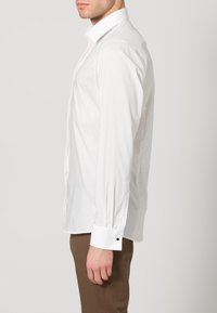 Witte lange mouwen dress shirt met een button-down kraag, ronde manchetten en een zachte textuur. Geen patronen, eenvoudig ontwerp.