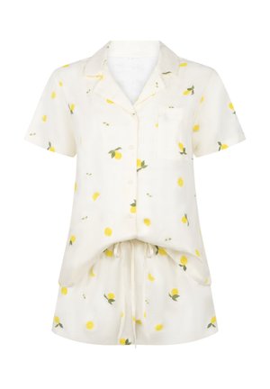 Λευκό πουκάμισο με κουμπιά και κοντά μανίκια και σορτς με κίτρινο μοτίβο λεμονιού και τσέπη στο μπροστινό μέρος του πουκάμισου.