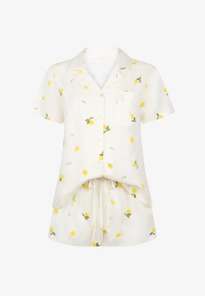 Λευκό πουκάμισο με κουμπιά και κοντά μανίκια και σορτς με κίτρινο μοτίβο λεμονιού και τσέπη στο μπροστινό μέρος του πουκάμισου.