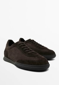Sneaker in suede marrone con profilo basso, design con lacci, tomaia testurizzata e suola in gomma nera. Cuciture a contrasto lungo i lati.