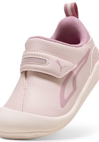 Puma athletic shoe in soft pink leather with a textured finish, featuring a Velcro strap, padded collar, and contrasting accents.