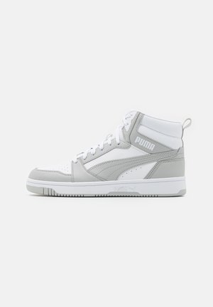Biało-szary wysoki sneaker Puma ze sznurowadłami, logo po boku i teksturowaną podeszwą, pokazany od zewnętrznej strony na jednolitym tle.