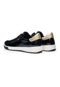 Baskets basses en cuir verni noir avec semelles blanches et accents métalliques dorés au talon, détail avec fermeture éclair latérale, photographiées sur fond blanc.