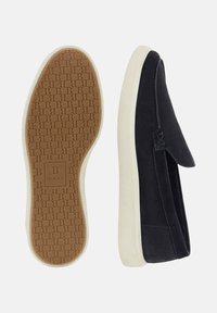 Tumesuede slip-on kingad valge kummitald. Tald on tekstuuriga mustriga, millel on logo "B" ja paindlik disain.