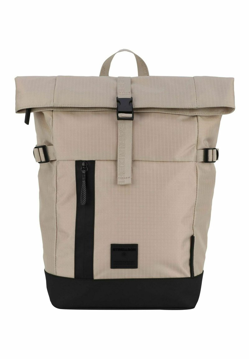 Sac à dos beige à rabat avec accents noirs, fermeture à boucle sur le dessus, zip latéral et bretelles ajustables ; présente un motif texturé.
