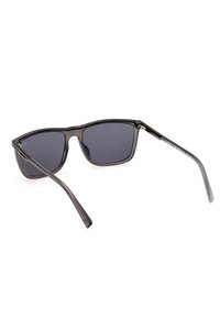 Ochelari de soare din plastic negru, cu o formă rectangulară elegantă, lentile gri și brațe subțiri transparente. Include branding subtil pe braț.