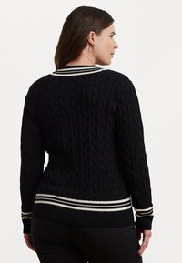 Πλεχτό πουλόβερ σε ναυτικό μπλε με σχέδιο καμπάνας. Διαθέτει ριγέ τελειώματα στα άκρα και τους καρπούς, καθώς και λευκές και κρεμ ρίγες στον γιακά και στο κάτω μ�έρος.