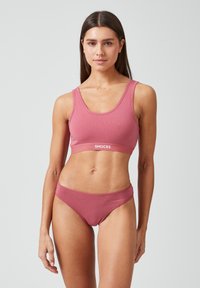 Różowy biustonosz braletka i pasujące majtki w stylu boyshorts wykonane z miękkiej bawełny, z elastycznym ściągaczem z logo. Prosty design o gładkiej fakturze i bez wzorów.