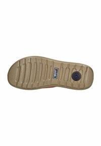 Rubber shoe sole in beige with textured tread pattern. Features a circular black accent and branding detail near the heel area.