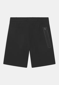 Zwarte sportshorts van zacht materiaal met een rekbare tailleband, een ritszak aan de zijkant en achterzakken voor opslag.