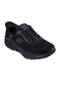 Zwarte sportieve schoen met een gestructureerde gebreide bovenkant, vetersluiting, gewatteerde kraag en een dikke, goed gedempte zool. Merken op de tong en zijkant.